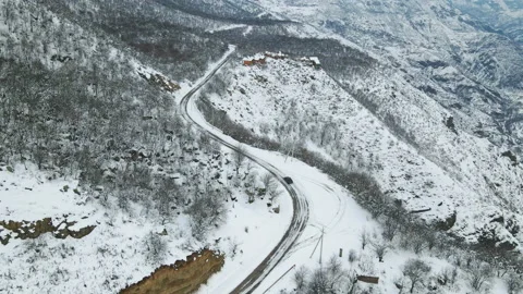 Aerial flight in winter landscape. Black car driving along winter covered snowy Stock Footage 163241753