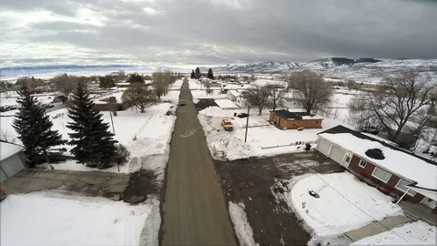 Aerial Flight winter small town road piles of snow on road side truck approaches Video stock 72364282