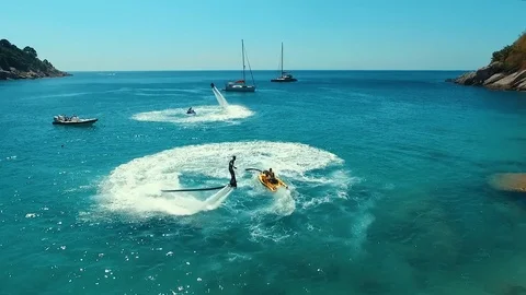 Aerial: Flip on flyboard on the beach. Stock Footage 70451260