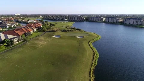 Aerial Florida Golf Course approaching Green next to water Stock Footage 126164688