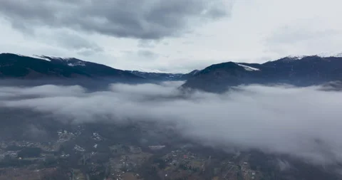 Aerial fly above clouds with blue white sky with mountains in the background. Stock Footage 174429685