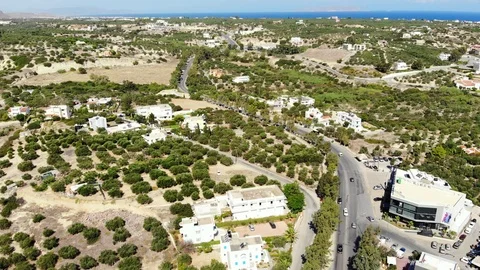 Aerial fly along winding road, olive trees, village and blue sea, Crete, Greece Stock Footage 101830756
