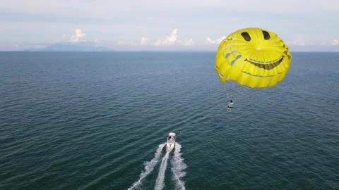 Aerial fly and look down yellow smile face parachute parasailing cruise Stock Footage 169071508