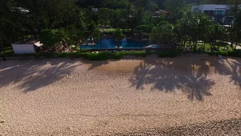 Aerial: Fly away from the pool on the beach. Stock Footage 69731046