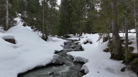 Aerial fly backward over mountain stream in winter, Lengau, Saalbach, 4K 60fps Vídeos de archivo 329930177