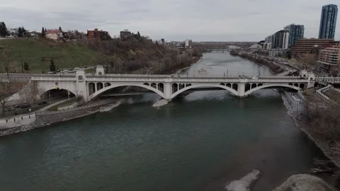 Aerial Fly Up of Centre Street Bridge and Bow River in Downtown Calgary Видео 336354528