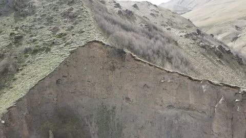Aerial fly-forward toward an eroded geological cliff and steep rocky slope Vídeos de archivo 337023205
