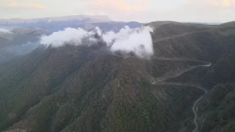 Aerial fly-forward of winding mountain serpentine road with low clouds Stock Footage 337023059