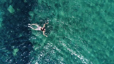 Aerial fly over active swimming woman in blue sea Stock Footage 101072941