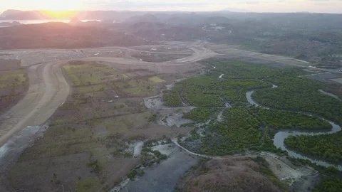 Aerial Fly over green fields, lush vegetation in indonesia with sun setting Stock Footage 129045703