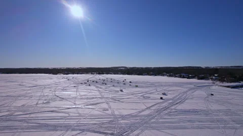 Aerial fly over intricate pattern of snowmobile race track on a frozen lake.. 動画素材 328379720