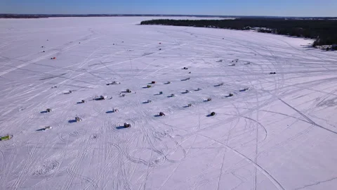 Aerial fly over intricate pattern of snowmobile race track on a frozen lake.. 動画素材 328379868