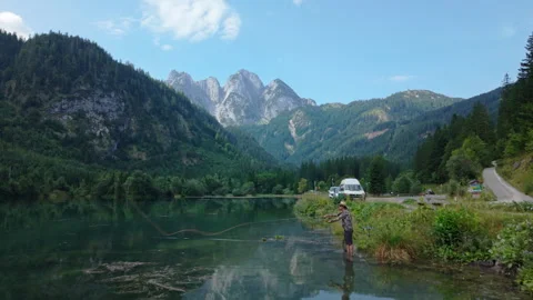 Aerial fly-over of man fly fishing with Gosaukamm mountain range background Vídeo Stock 331602029
