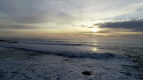 Aerial Fly Over ocean waves into sunset 動画素材 112982649