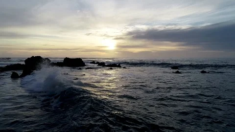 Aerial Fly Over ocean waves and rocks into sunset 動画素材 112982698