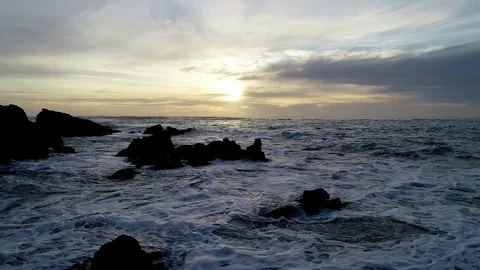 Aerial Fly Over ocean waves and rocks into sunset 動画素材 112986884