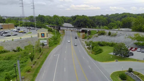 Aerial fly over of an old train bridge with cars and grocery store nearby Stock-Footage 128827991