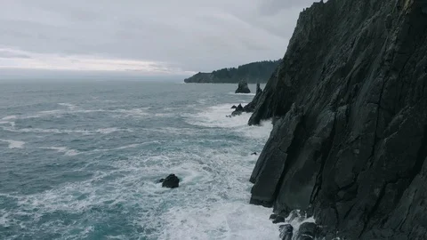 Aerial fly over Pacific Ocean crashing into the Northwest coastline or Oregon Stock Footage 122681837