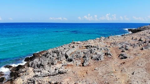 Aerial fly over rocky beach, stone pyramids and blue sea, Crete, Greece Stock Footage 101160116