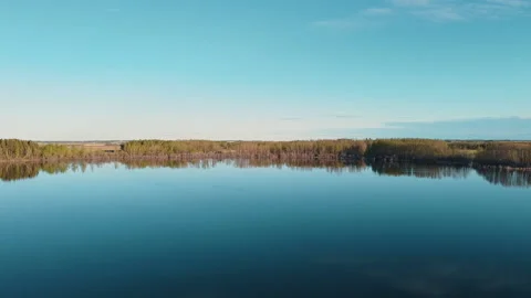 Aerial Fly Over Small Lake Towards Distant Trees Stock Footage 131275232
