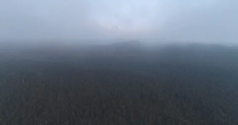 An aerial fly through the clouds looking back at Fox Glacier Mountain Range on Stock Footage 100125355