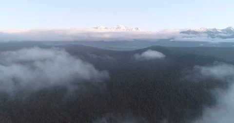 An aerial fly through the clouds looking back at Fox Glacier Mountain Range on Stock Footage 100125708