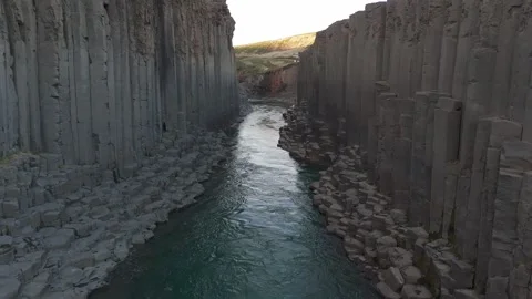 Aerial fly-through shot through Stuðlagil Canyon and river with basalt columns Video stock 279667041
