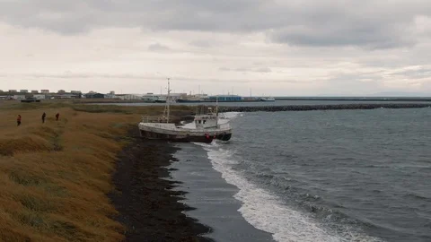 Aerial fly through view of a ship wreck by a small harbour in West Iceland Stock Footage 116183232