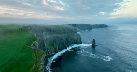 Aerial flyby of Cliffs of Moher coastline with sea stack and drifting fog Stock Footage 339504851