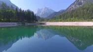 Aerial: Flying Above Beautiful Green Lake Towards The Rocky Mountains Stock Footage