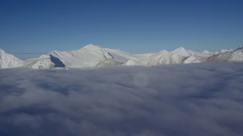 Aerial: Flying Above Clouds over Snow Capped Mountains/Landscape Stock Footage 72894817