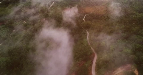 AERIAL. Flying above the clouds over road and rice terraces in Thailand at Stock Footage 85287461