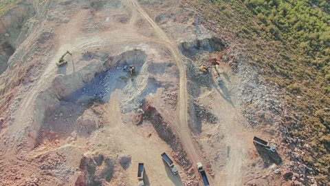 Aerial, flying above stone quarry with working many heavy trucks and machines. Video stock 100242753