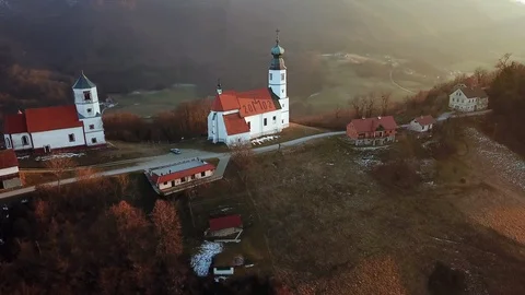 Aerial: Flying arround pair of old catholic churches on top of the hill. Stock Footage 109159011