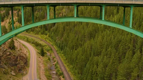 Aerial: Flying back from under mountain road bridge Stock Footage 94595710