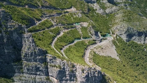 Aerial flying behind steep cliff SH20 winding road Albania 库存影片 330878717