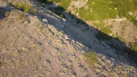 Aerial flying camera view of young man in casual walking on the mountain edge Stock Footage 93002970