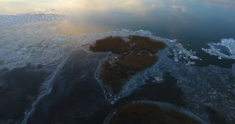 Aerial, flying down and away from the shore to the ice covered lagoon - 5 動画素材 101551386