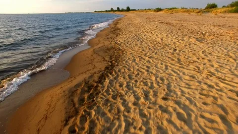 Aerial Flying Low Over Sandy Beach Sea Waves at Golden Sunset Stock Footage 101540000