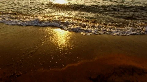 Aerial Flying Low Over Sandy Beach Sea Waves at Golden Sunset Stock Footage 101540451