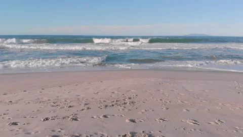 Aerial: flying low over a surf beach in New Zealand Видео 132144207
