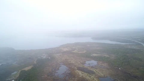 Aerial of flying over the cold arctic tundra through fog Stock Footage 78476532