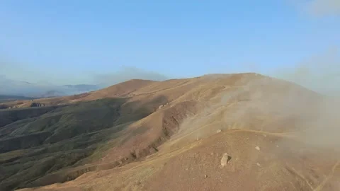 AERIAL flying over the hillside on which the fog moves on a sunny autumn day Video stock 131553064