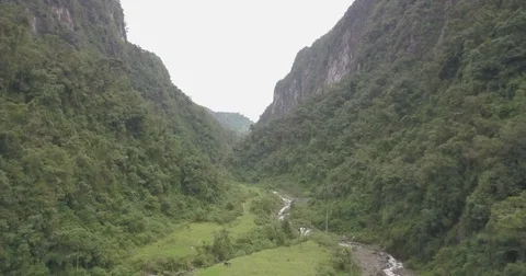 Aerial flying over a river through a tall green canyon in Colombia Vídeos de archivo 80658597