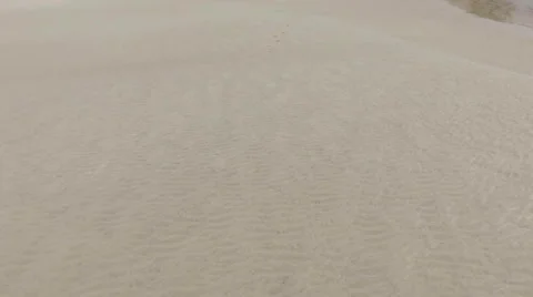 Aerial flying over small tidal beach following the foot prints Stock Footage 68815744