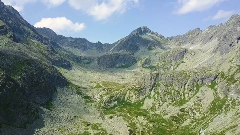 AERIAL: Flying over steep hill towards the mountains Vídeo Stock 79192524