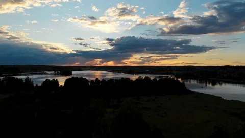 Aerial flying over trees toward a stunning sunset with reflection on the lake Stock Footage 95919013