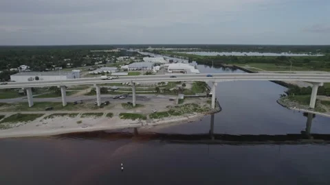 Aerial flying parallel to bridge and highway over intracoastal and bay Stock Footage 157366243