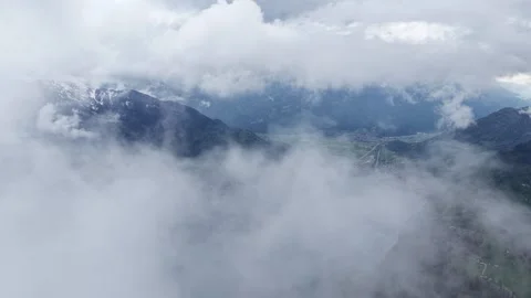 Aerial flying through clouds mountain valley reveal Switzerland Stock Footage 344848678
