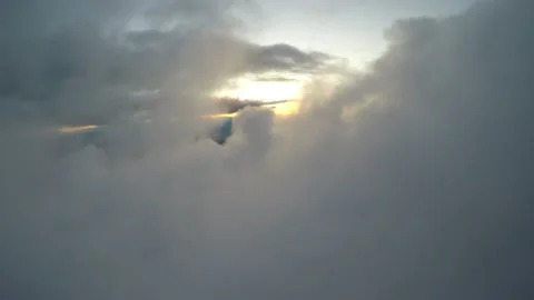 Aerial flying through hole in cloud toward sunlight sunset Vídeo Stock 237884128